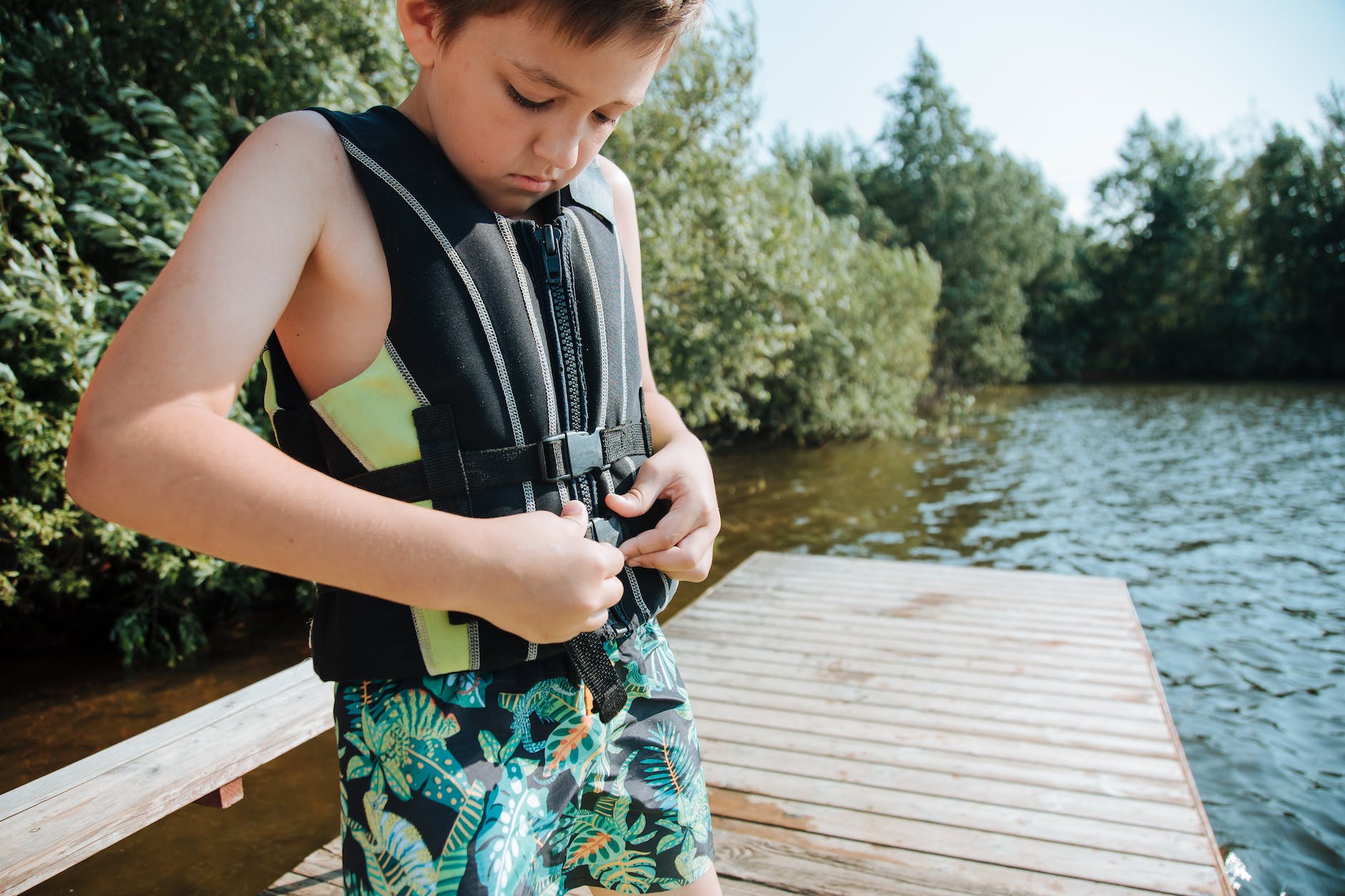 boy putting on life jacket