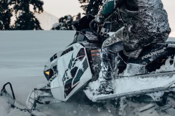 a man riding white and black snow mobile
