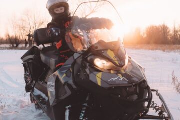 person on snowmobile in winter field